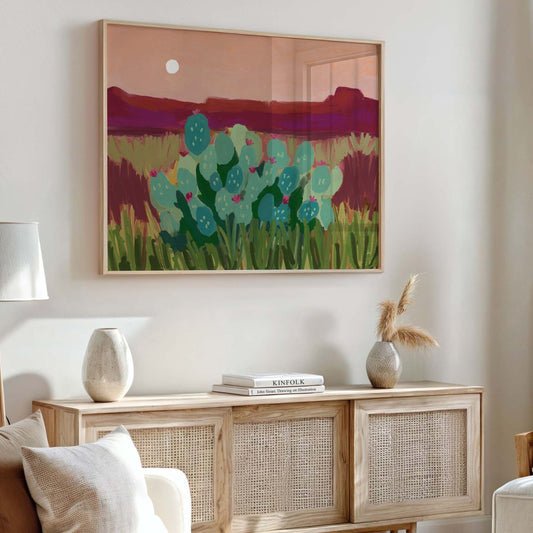 Giclée art print of a desert night landscape with teal cacti in bloom, magenta mountains and a soft moon over a warm rose sky